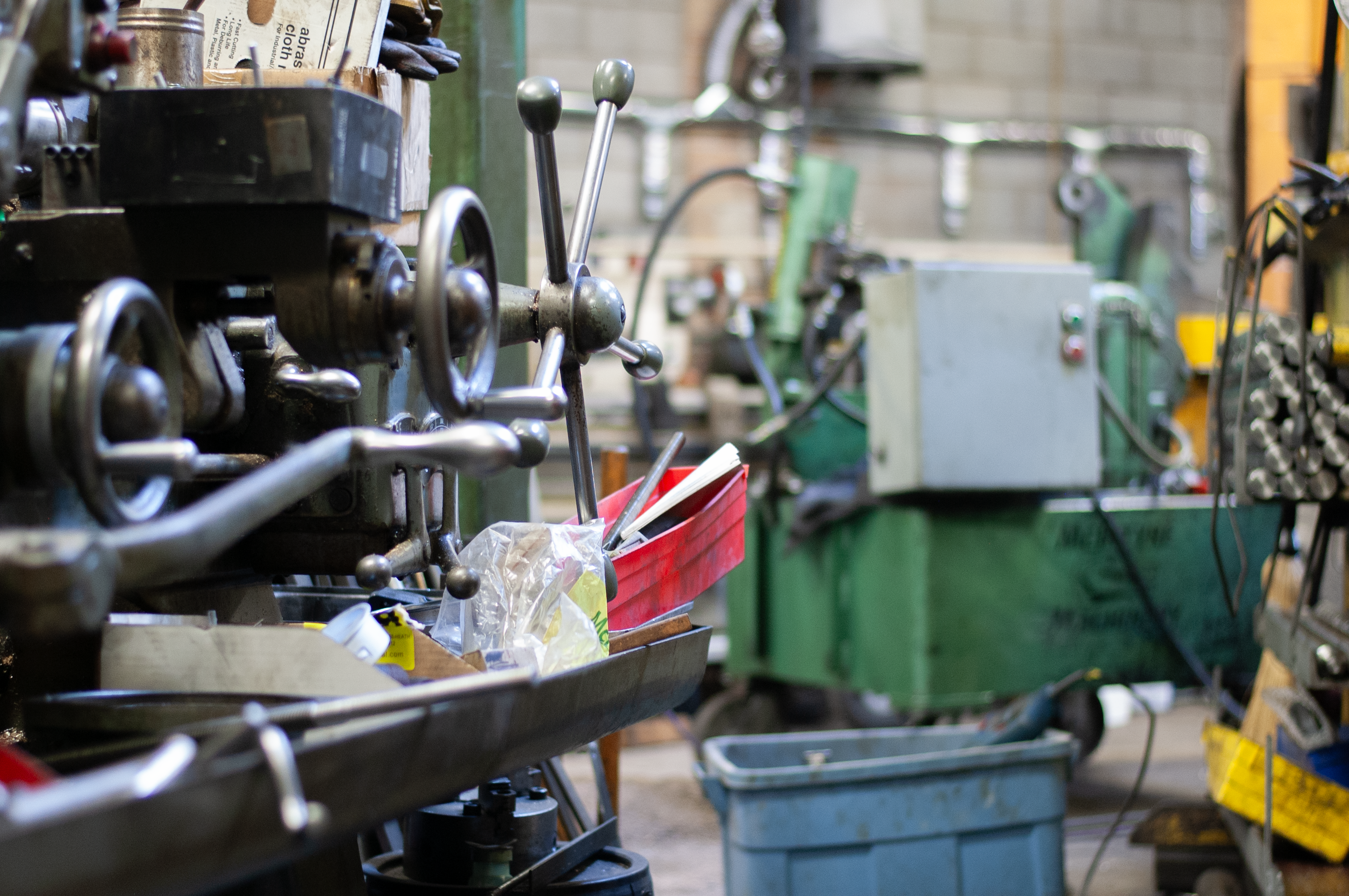 A machining workshop bench with a bucket of tools on it.