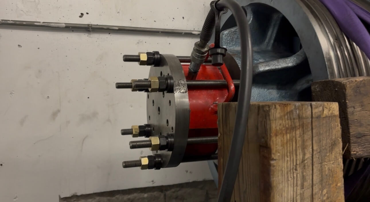 Portable machining head bolted to an elevator sheave in a machine room